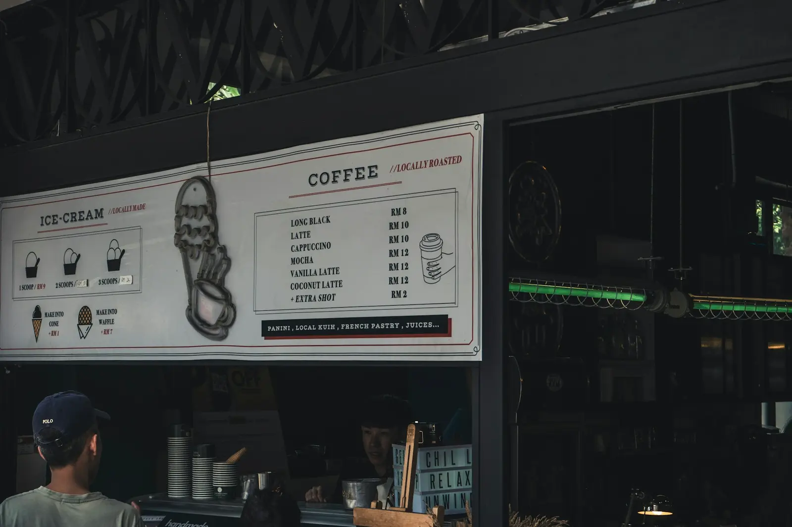 A person standing in front of a coffee shop at dawn